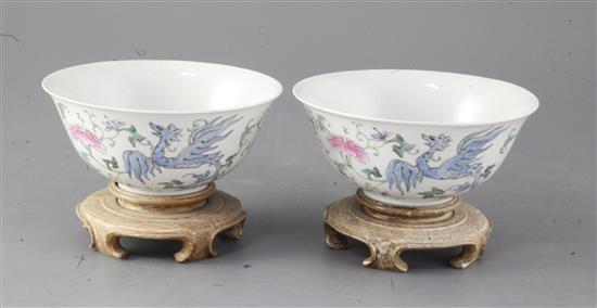 A pair of Chinese famille rose phoenix bowls, Guangxu period, 15.4cm diameter, wood stands